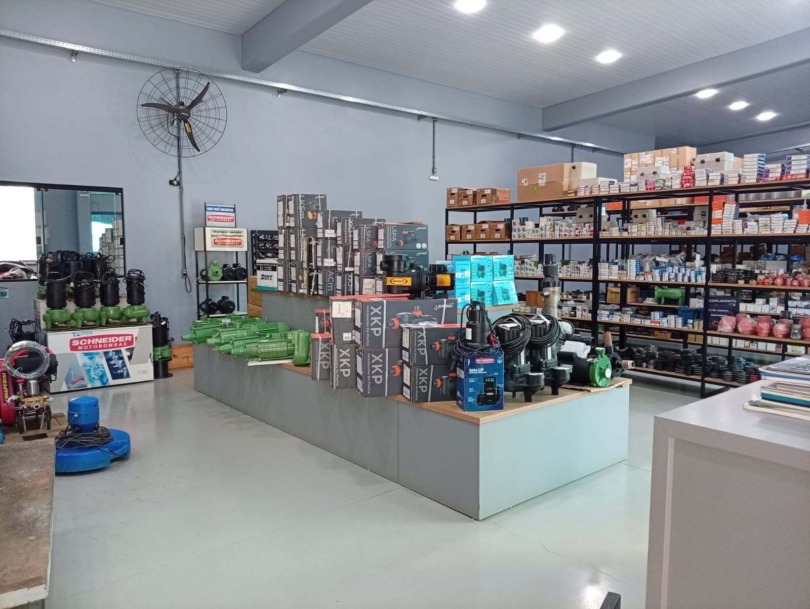 Interior da loja LG Motores com motobombas e prateleiras de peças