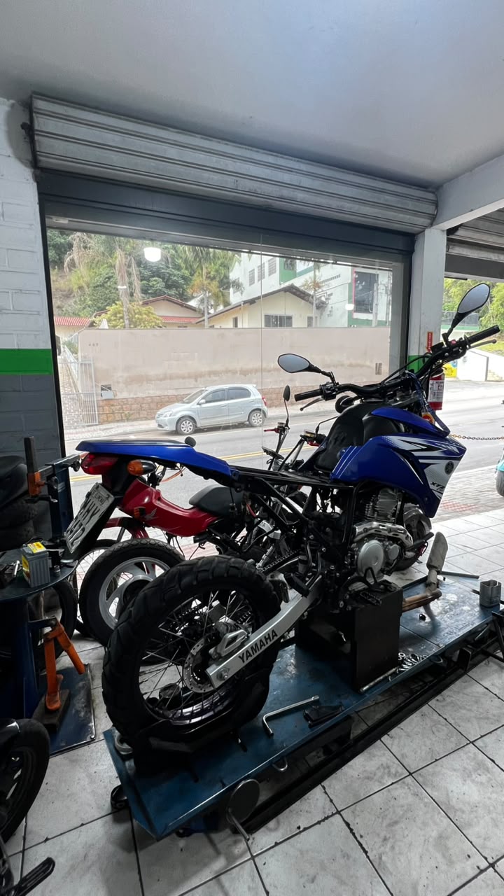 Yamaha XTZ azul no elevador da oficina Brayan Motos