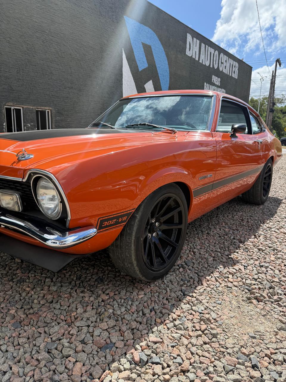 Ford Maverick laranja em frente à DH Auto Center