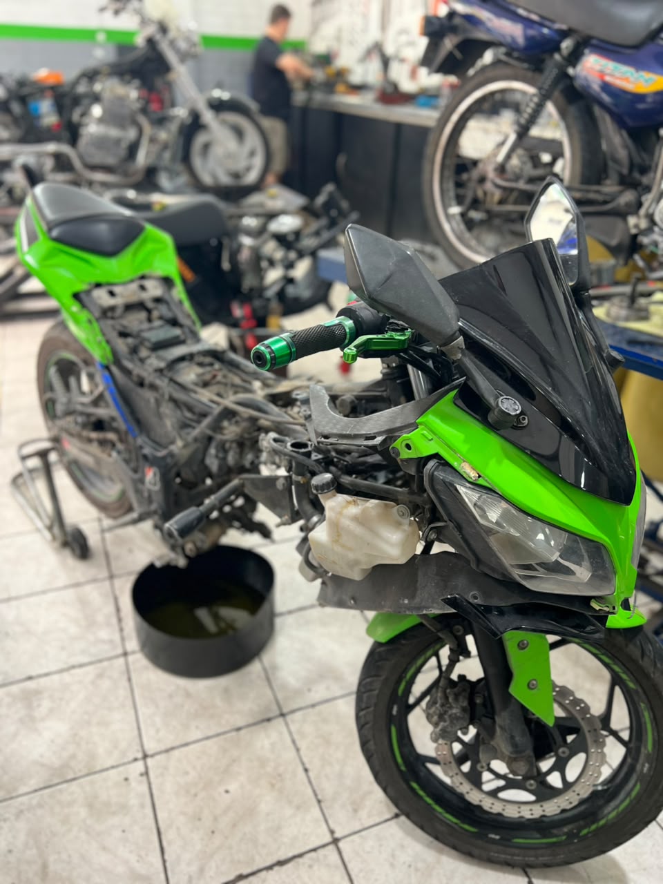 Kawasaki Ninja verde em manutenção na oficina